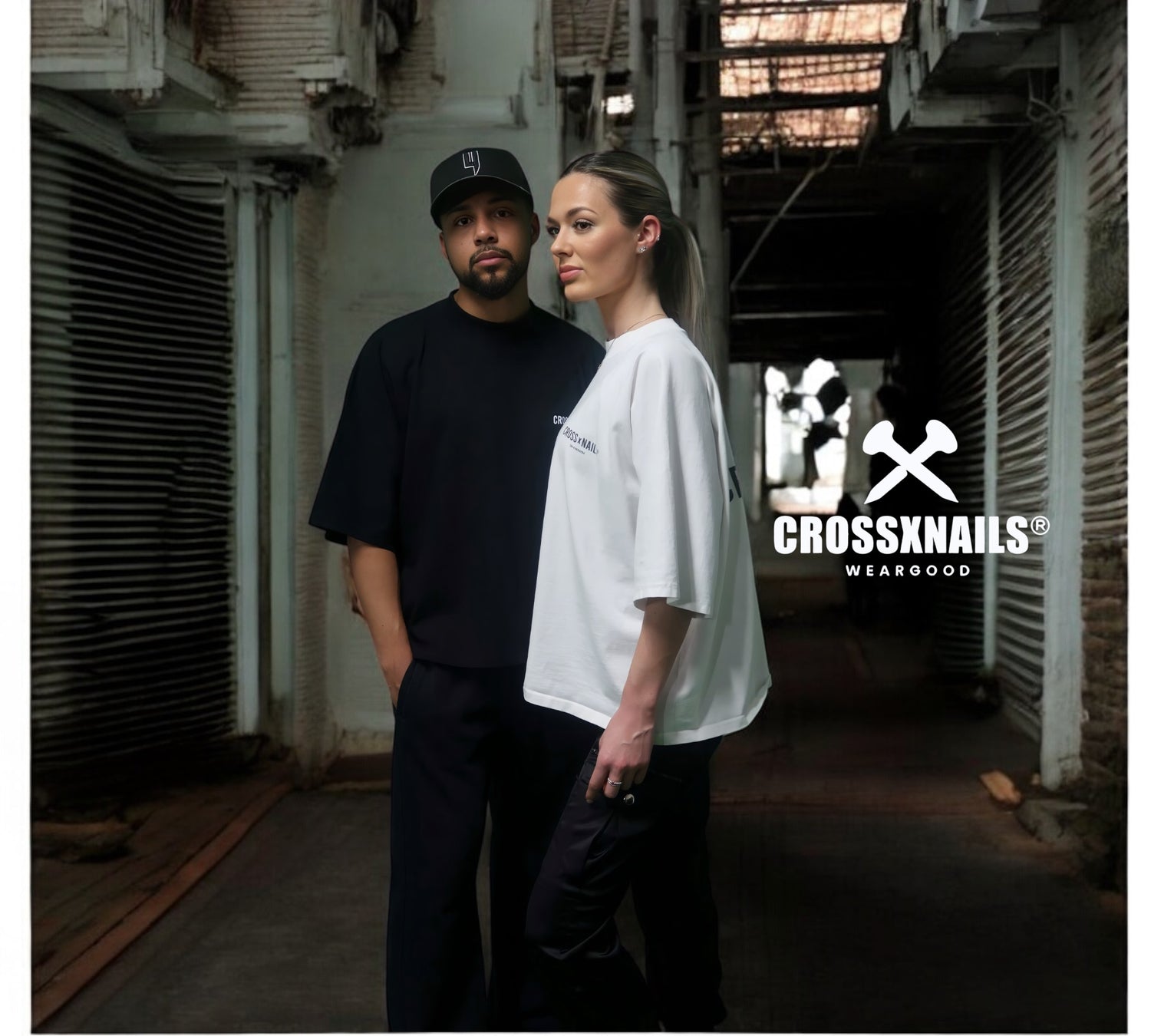 Two models showcasing Crossxnails® WearGood oversized streetwear tees in an urban setting. Image represents the full product collection.